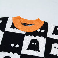 Close-up of black and white ghost checkerboard knit with orange ribbed crew collar