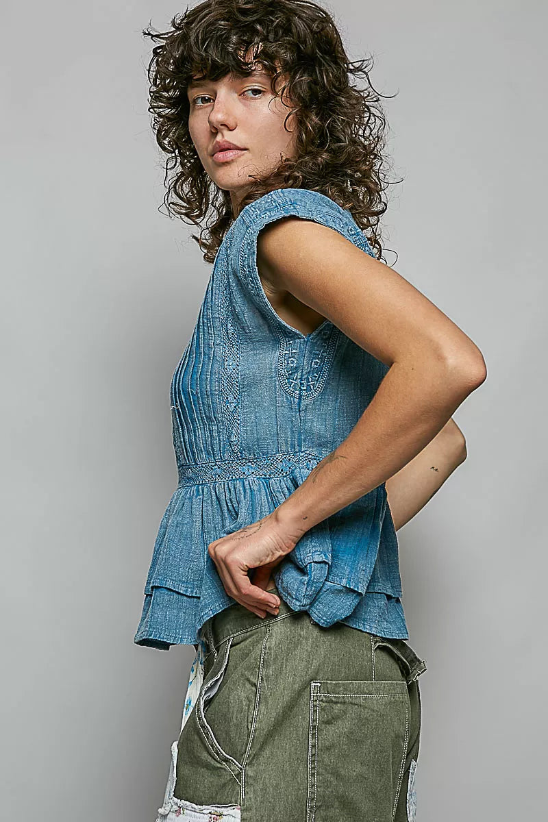Denim blue sleeveless pintuck peplum blouse with ruffled hem and button front