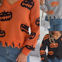 Orange knit V-neck sweater with black jack-o’-lantern intarsia and distressed fringe hem