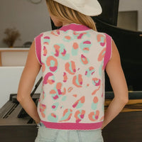 Back view of ivory sleeveless sweater vest with pink trim and leopard-style print.