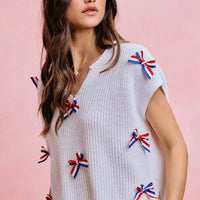 Off-white knit dolman sweater top with colorful ribbon bow details on the front
