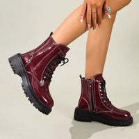 Burgundy lace-up block heel boots with side zipper, patent shine, and chunky tread