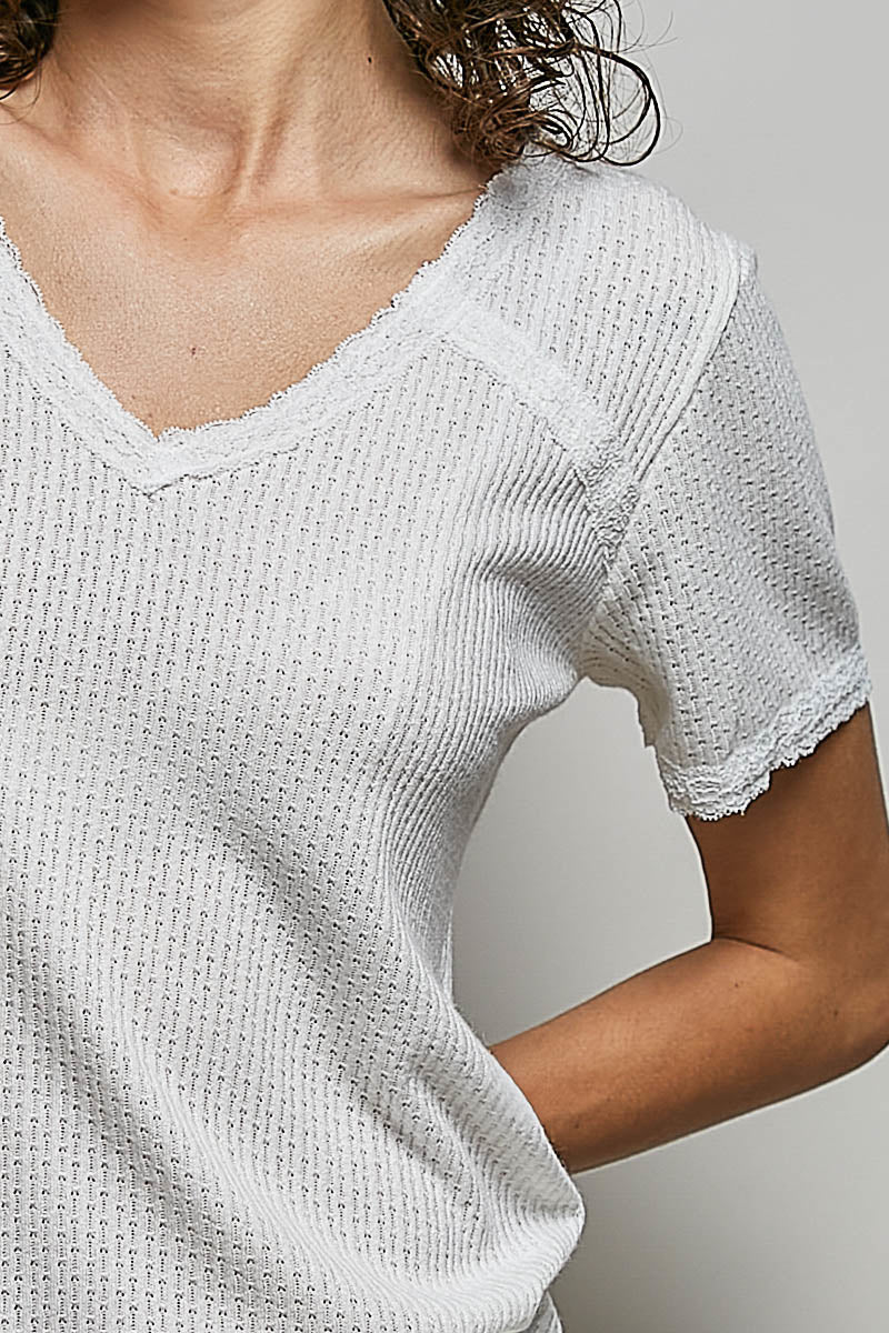 Off-white textured V-neck short-sleeve t-shirt close-up, scalloped lace trim