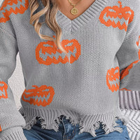 Gray knit V-neck pumpkin sweater with orange jack-o’-lanterns and frayed hem detail