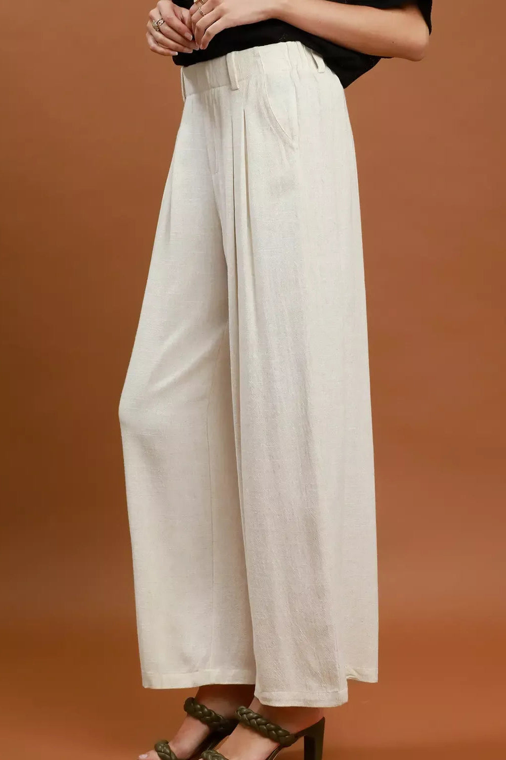 Cream high-waist wide-leg trousers with front pleats and relaxed straight legs