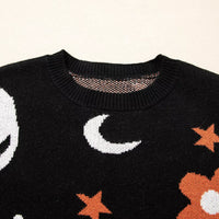 Black crewneck sweater close-up with moon and star knit pattern across the chest