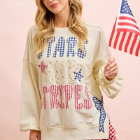 Cream sweatshirt with blue star top, red stripe bottom, and blue bow patch at hem.