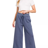Blue indigo wide-leg center-seam pants with an off-white short-sleeve cropped top