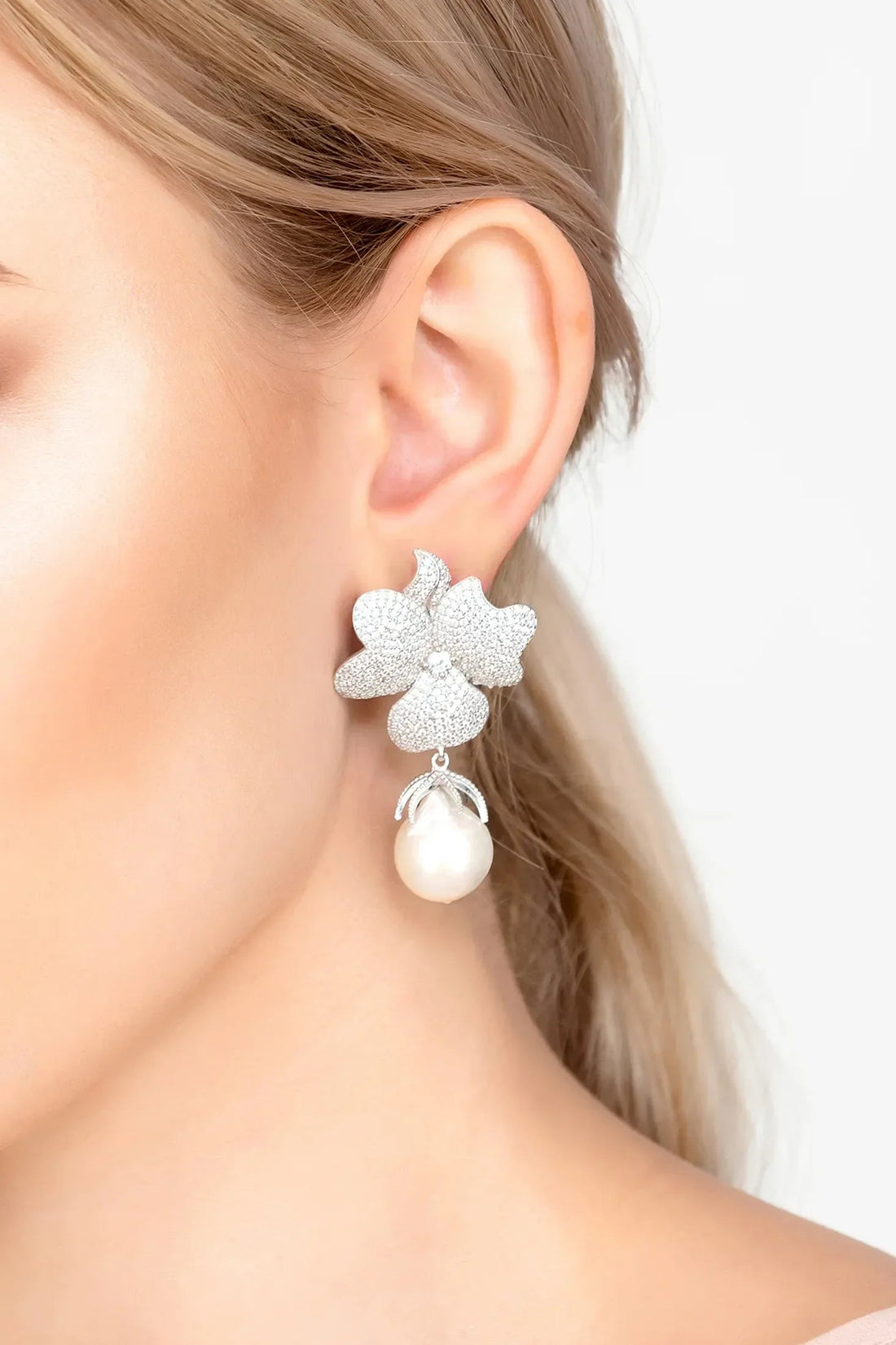 Flower drop clip-on earrings with silver glitter flower and white pearl drop, close-up