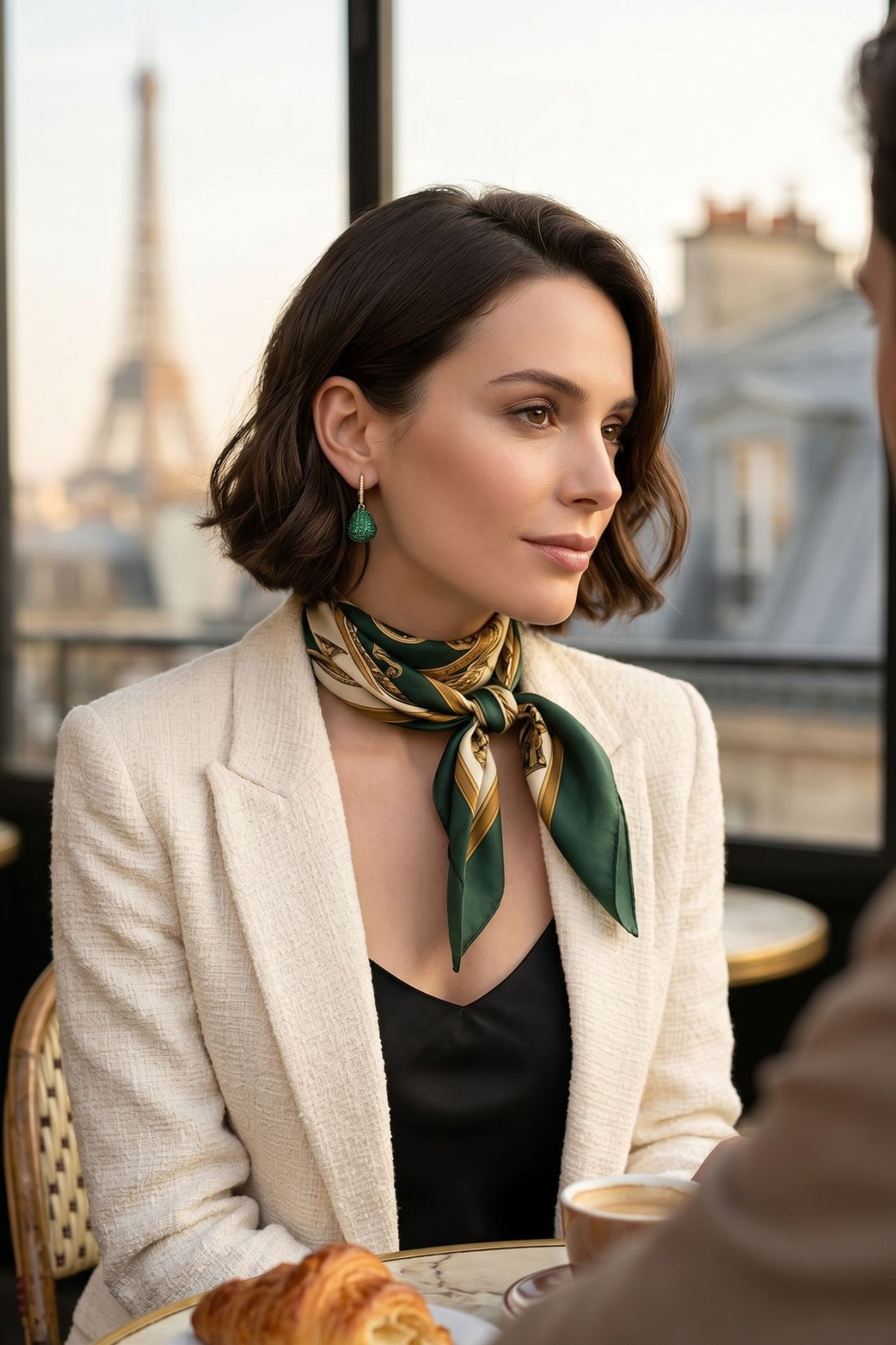 Emerald-green teardrop gemstone drop earring on gold hook, side view