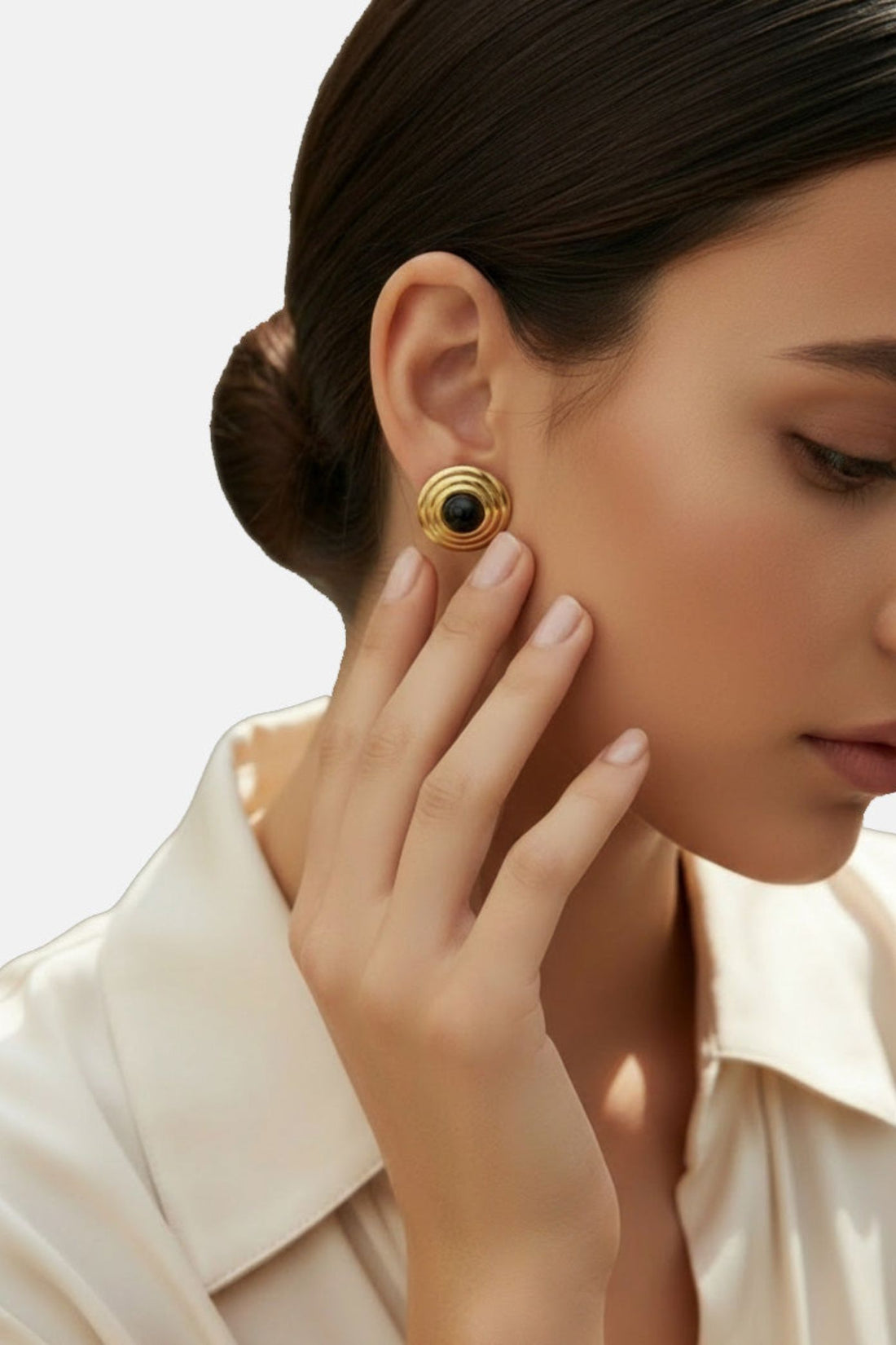 Gold spiral round onyx stud earrings on the ear.