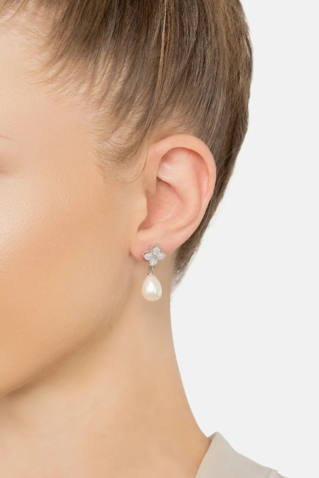 Silver-tone clover cz stud with pearl drop earring, side view on ear