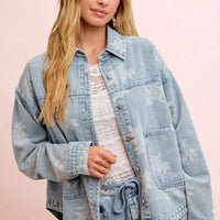 Light blue washed denim jacket with white floral print, button front, and front pockets