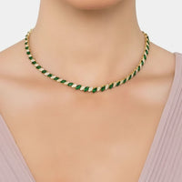 Emerald-green and gold-tone tennis necklace on model neckline, teardrop stones row