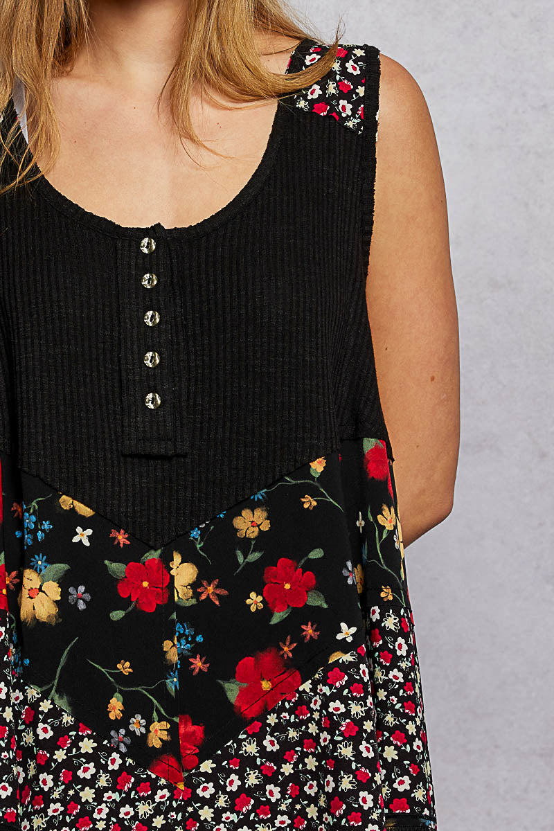 Black ribbed tank top close-up: round neck, small buttons, floral woven patch
