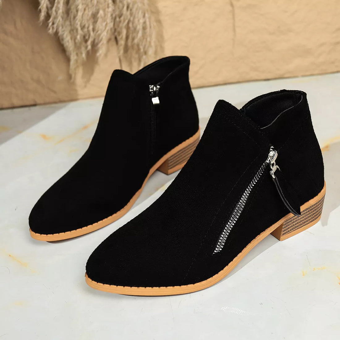 Black suede point-toe block heeled ankle boots with side zipper, tan outsole and block heel