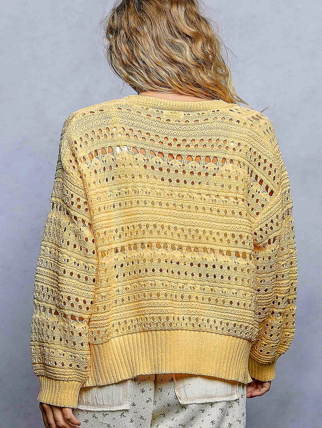 Yellow open-knit button cardigan with allover pointelle texture and ribbed cuffs
