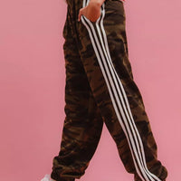 Camouflage track pants with white side stripe detail and relaxed tapered leg.