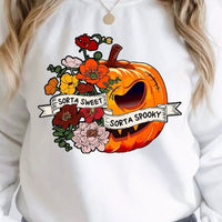 White crewneck sweatshirt with orange pumpkin graphic and flower accents