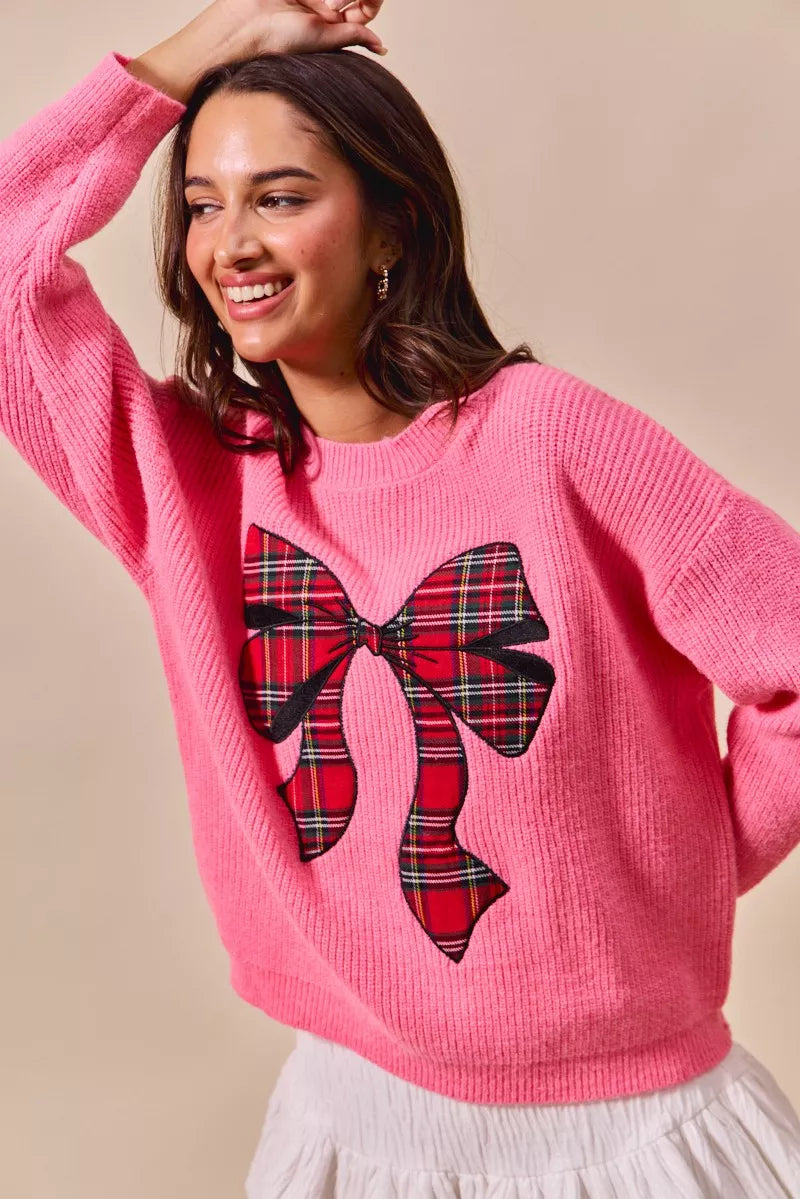 Pink holiday sweater with plaid ribbon bow graphic