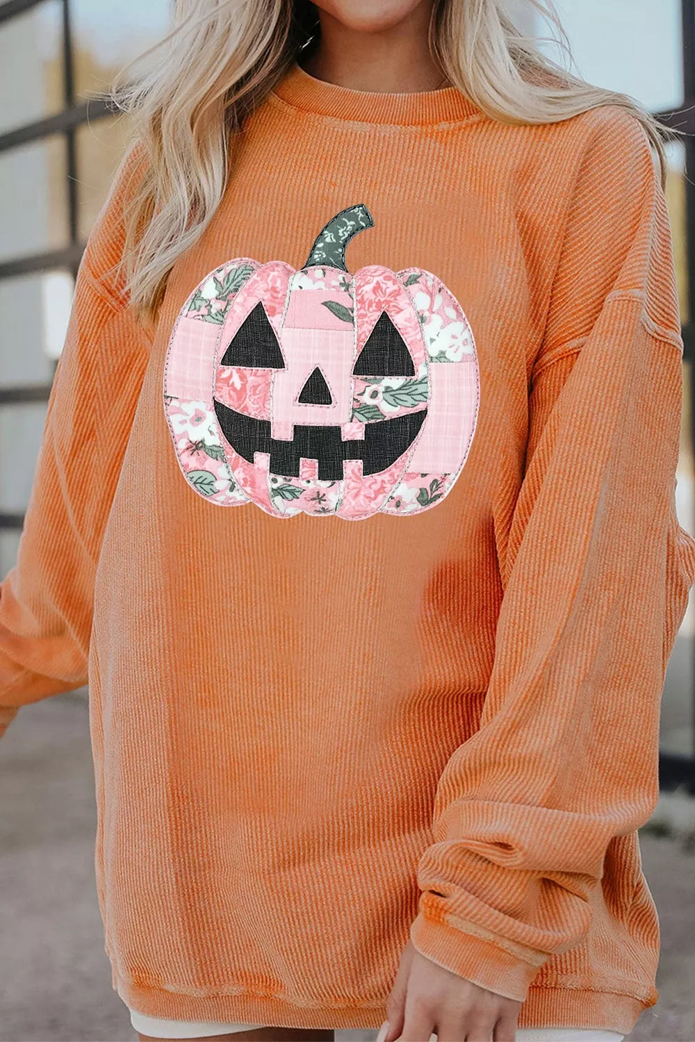 Orange sherbet tunic sweatshirt with patchwork pumpkin graphic and long cuffed sleeves