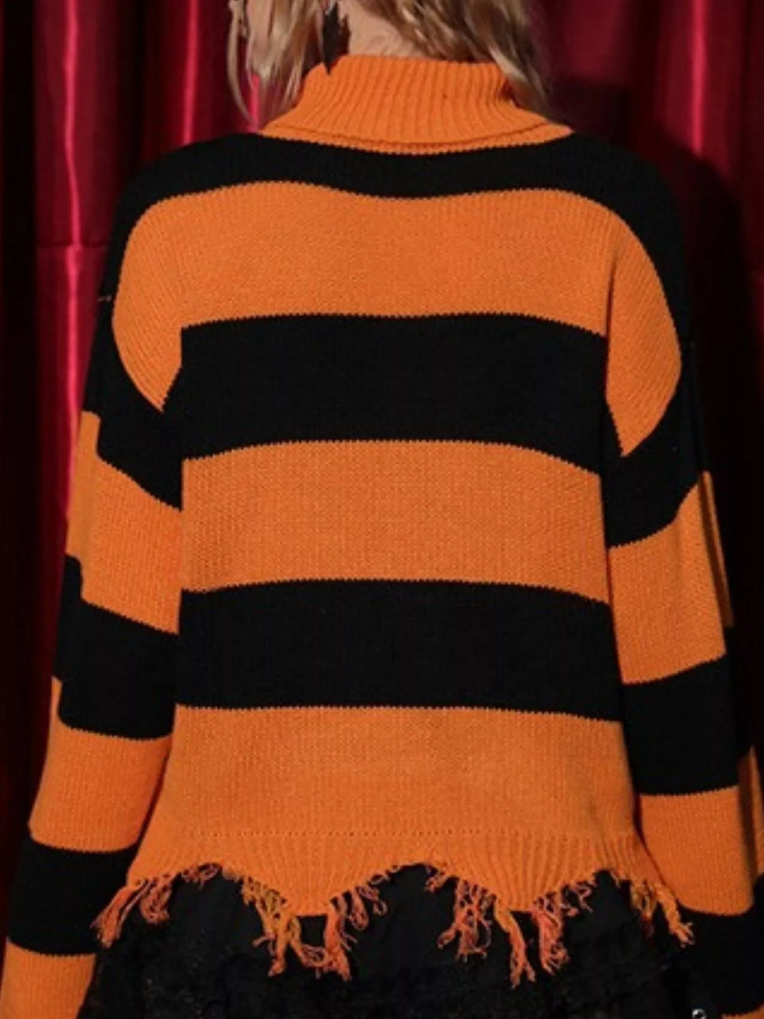 Orange and black striped turtleneck sweater with fringe hem, long sleeves, back