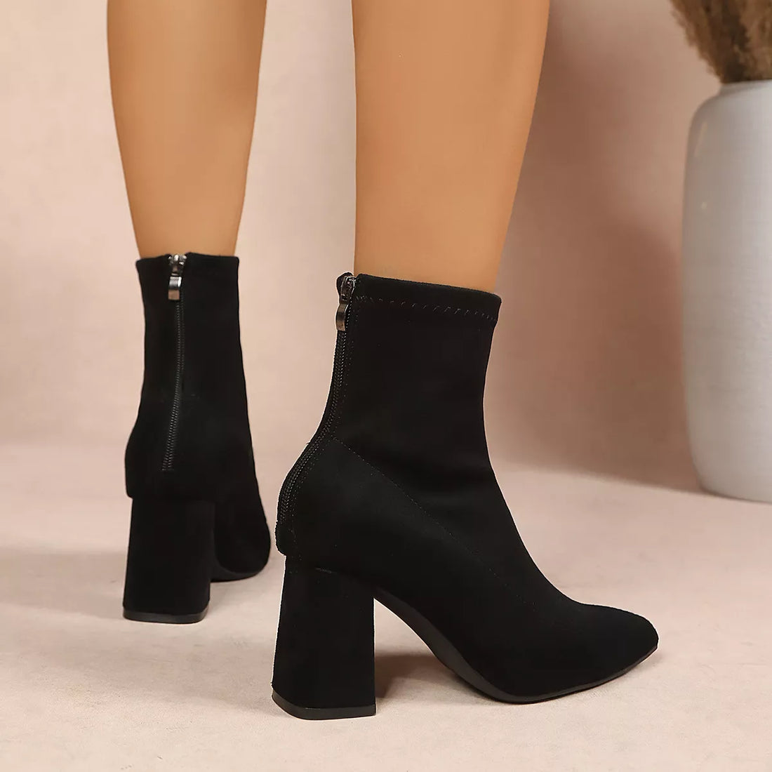 Black point-toe ankle boots with stacked block heel, rear/side view