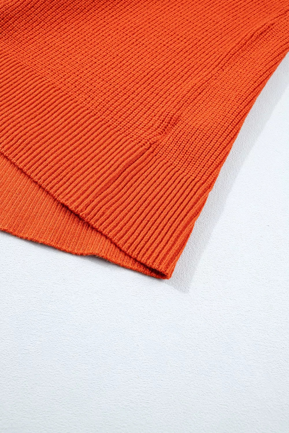 Orange ribbed knit sweater sleeve cuff and hem detail