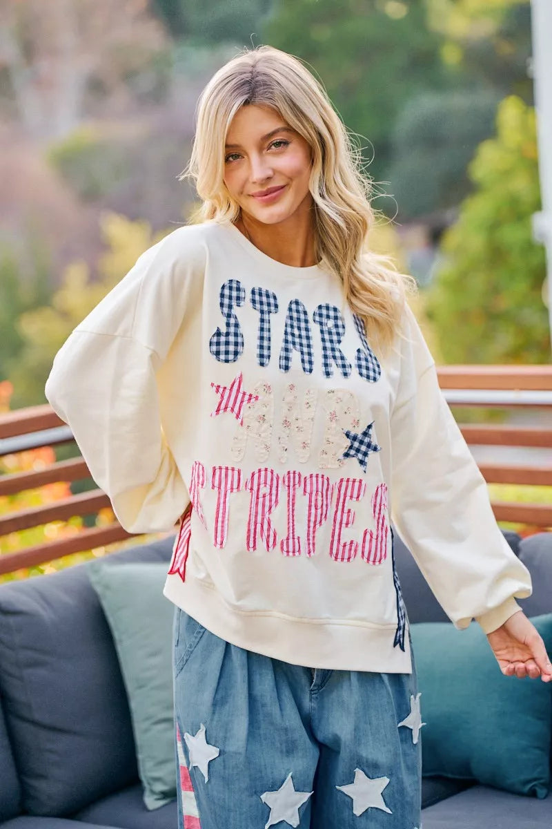Cream crewneck sweatshirt with stars-and-stripes patch-style graphic, relaxed fit