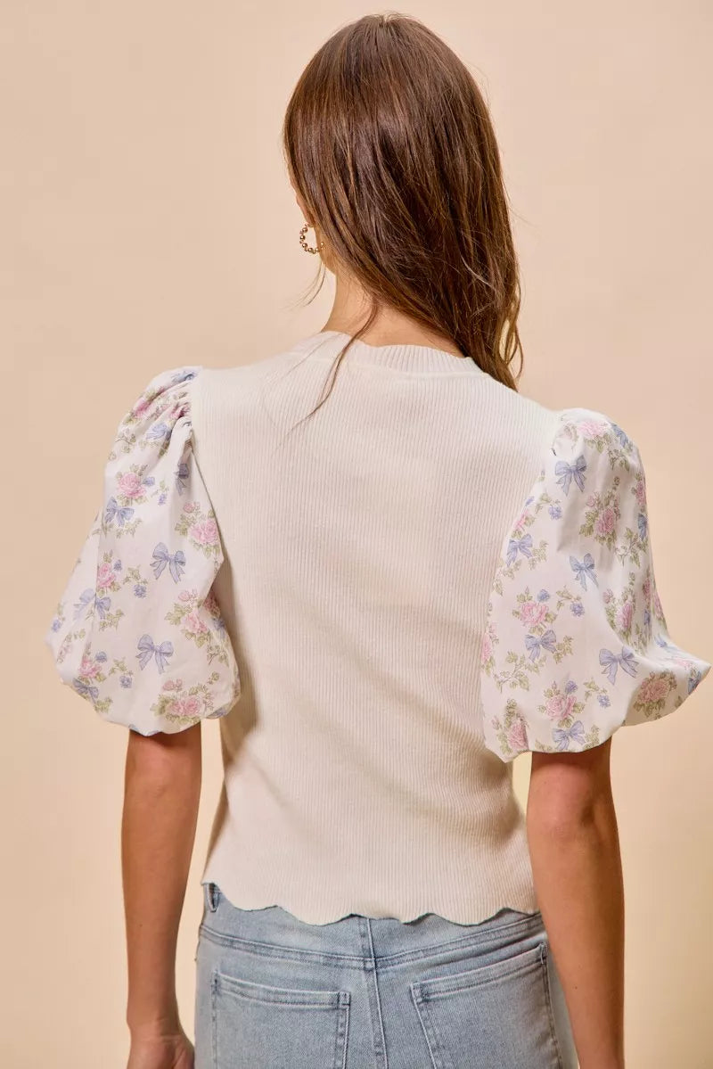 Back view: white knit sweater top with floral puff sleeves