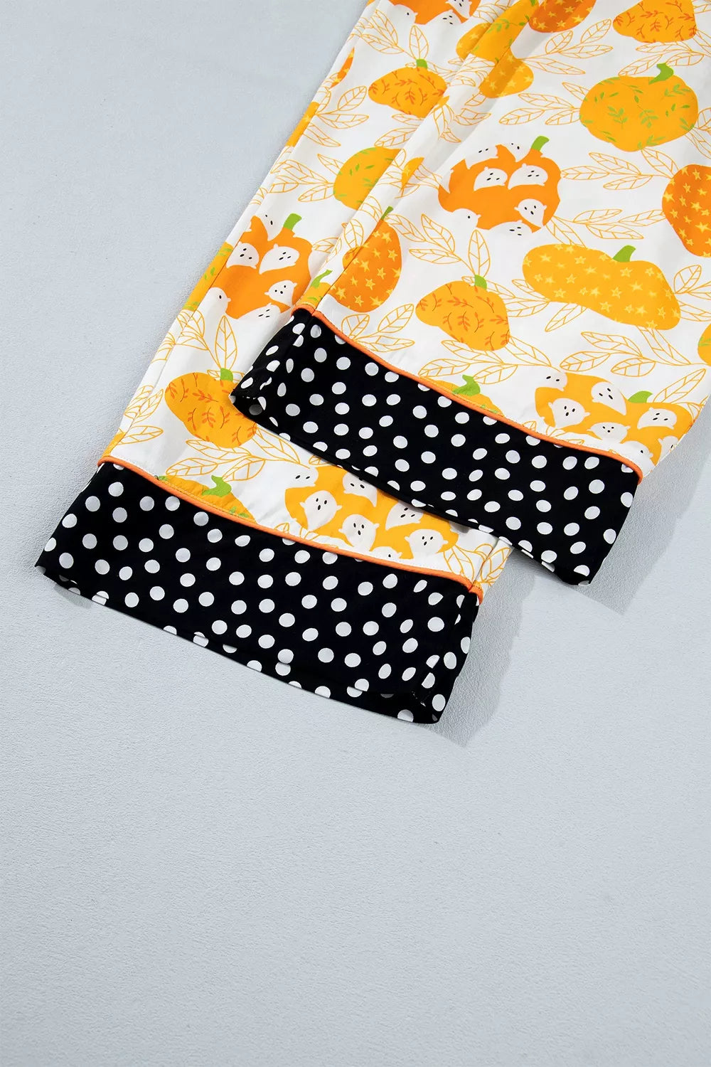 Printed lounge shorts with black polka-dot panels and pumpkin print trim