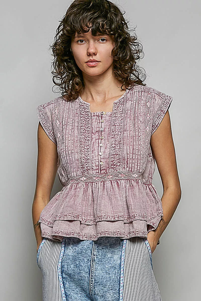 Pink sleeveless embroidered blouse with pintuck detailing and gathered waist peplum.