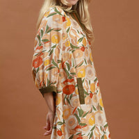 Floral shift mini dress, side view, with olive contrast trim and three-quarter puff sleeves