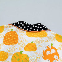 Close-up of pumpkin print fabric with black polka-dot collar trim