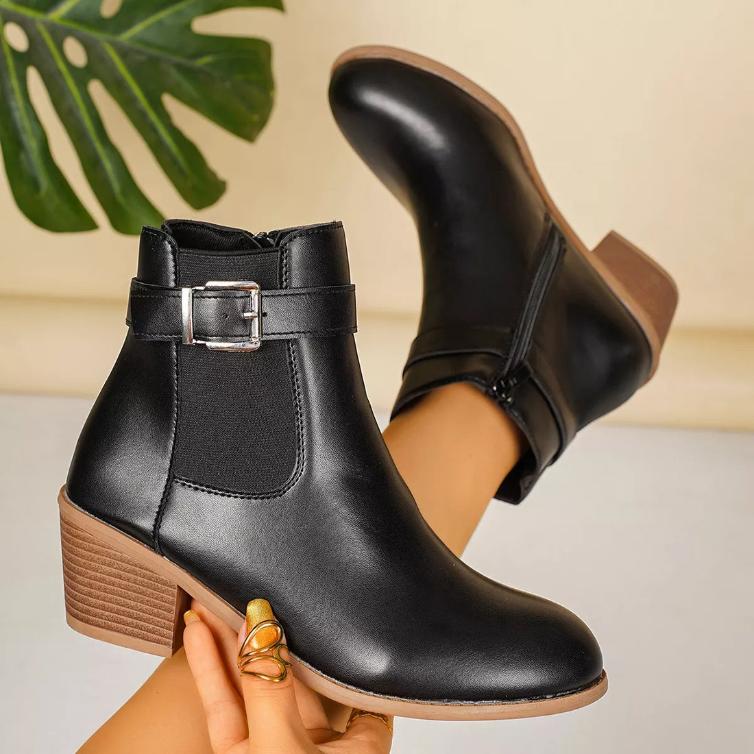 Point-toe block heel boots in black with buckle strap and rounded point toe