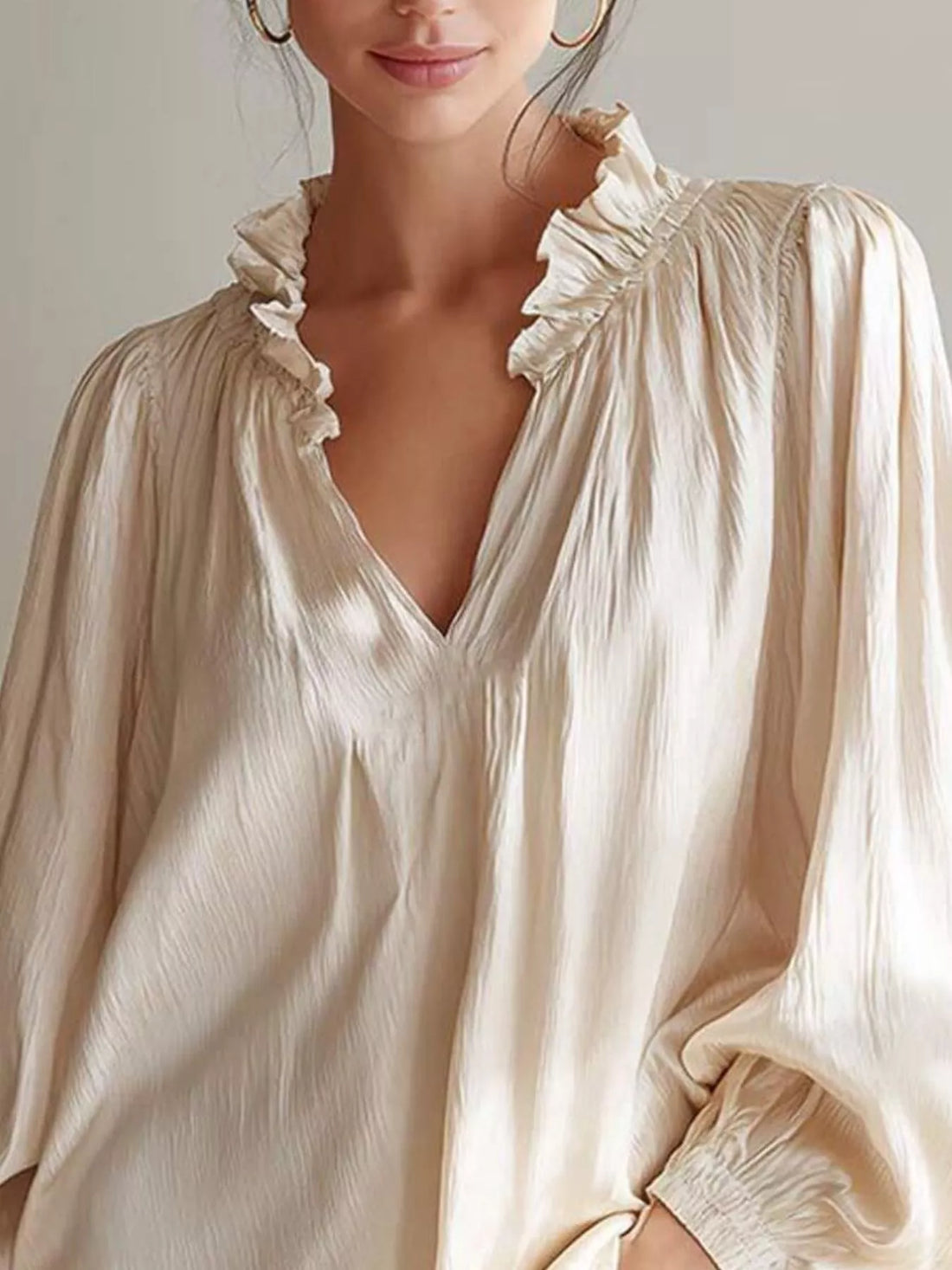 Beige blouse with V-neck and ruffled shoulder trim, long puff sleeves