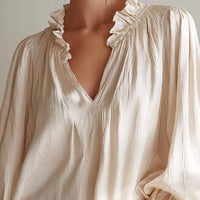 Beige blouse with V-neck and ruffled shoulder trim, long puff sleeves