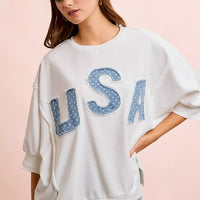 Ivory french terry pullover top with blue "USA" letter applique and draped dolman sleeves