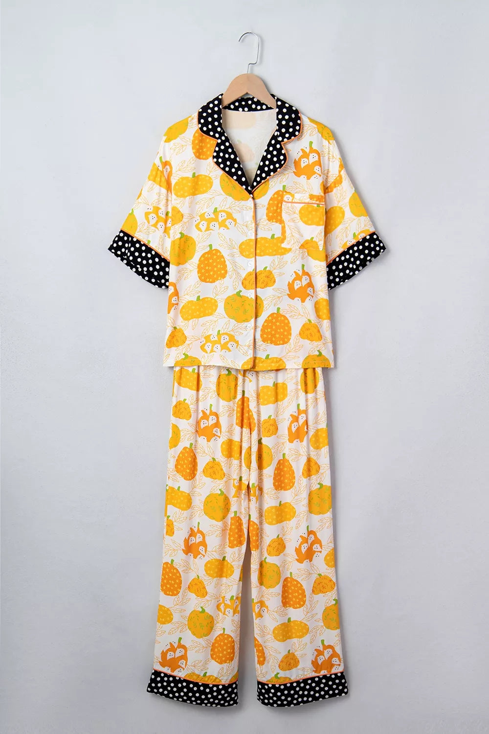 Laid-out pumpkin print pajama set with polka-dot-trim collar and cuffs, button-front top