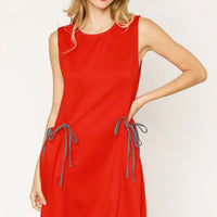 Red sleeveless tank dress with round neck, pockets, and ribbon-tie detail