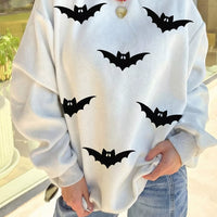 Light gray reversible mock-neck sweatshirt with black bat print and red collar trim