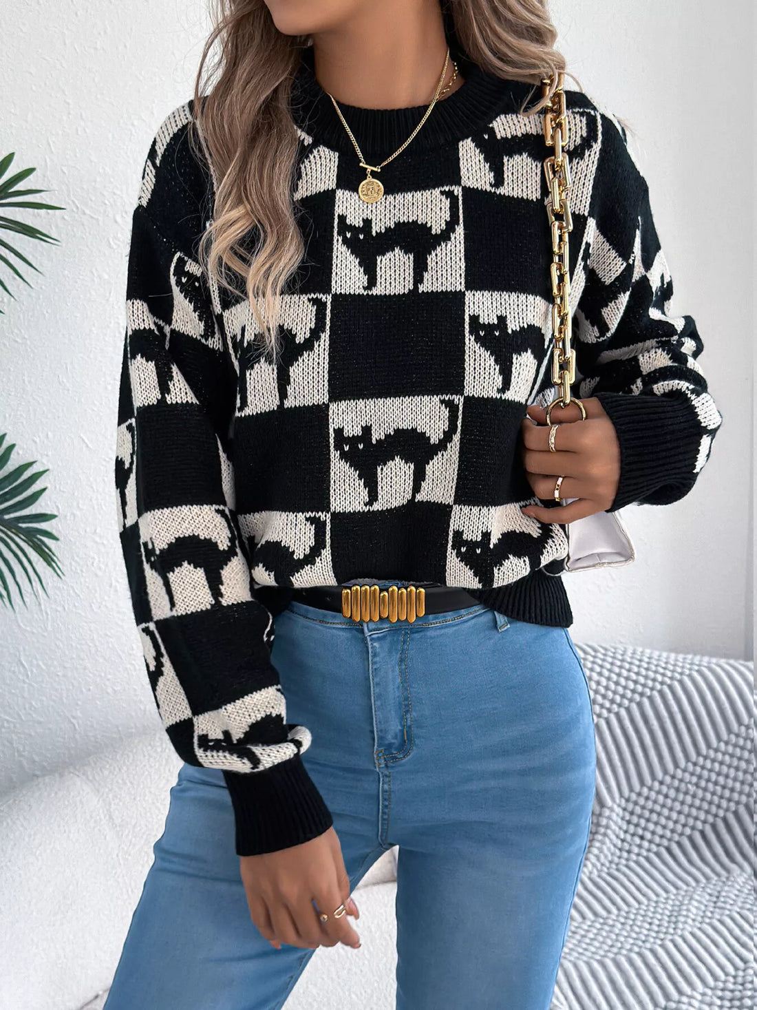 Black and cream ghost checkerboard knit sweater with long sleeves and ribbed neckline