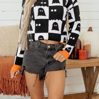 Black and white ghost checkerboard sweater with orange crew neck and ribbed cuffs