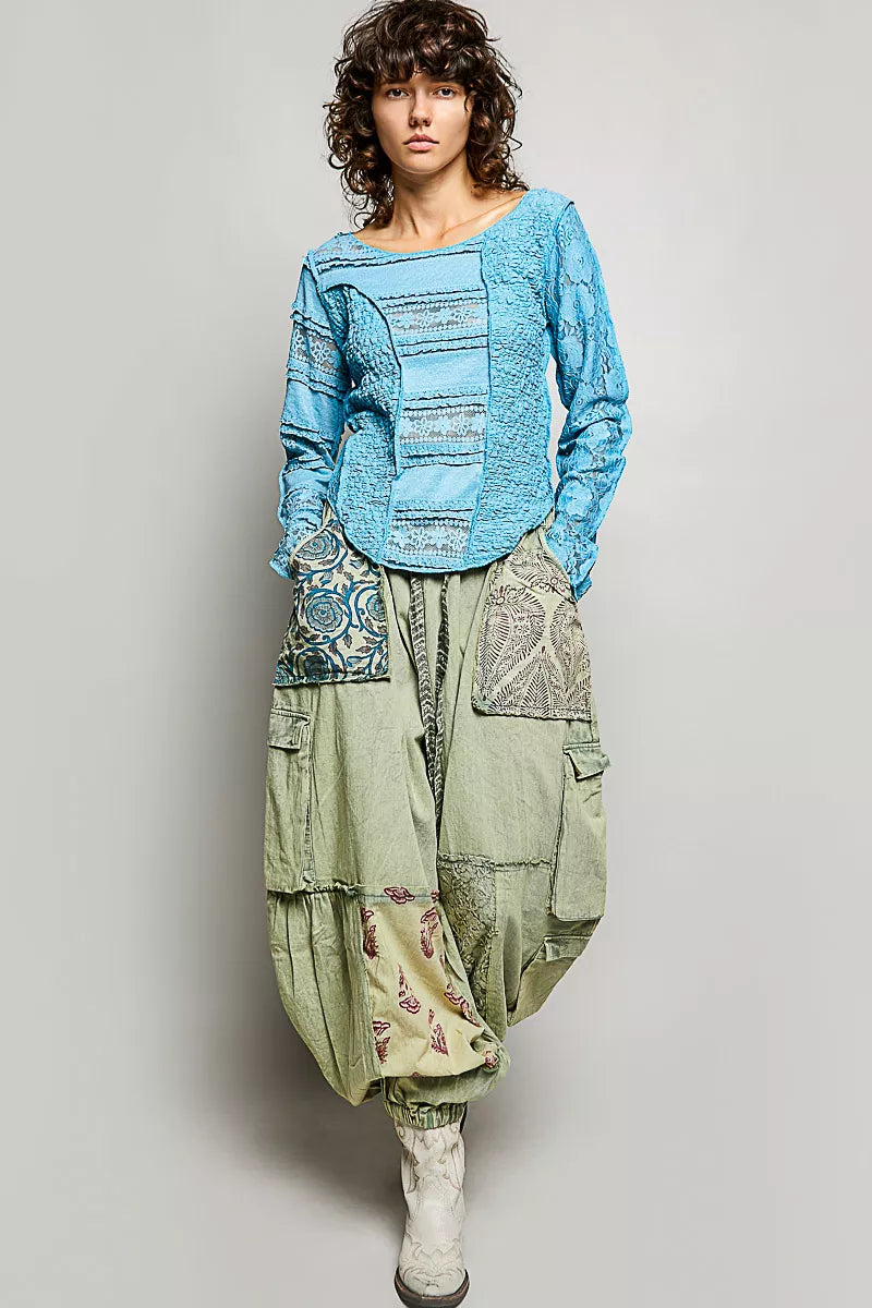 Teal blue lace patchwork long-sleeve top with exposed seams and round neckline