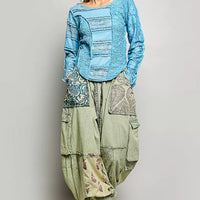 Teal blue lace patchwork long-sleeve top with exposed seams and round neckline