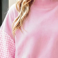 Blush pink loose tunic sweatshirt with ribbed crew neck and plaid sleeve