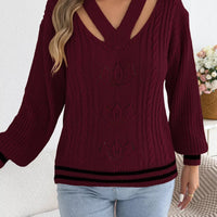 Burgundy cable knit sweater with V-neck cutouts at shoulders and ribbed bottom