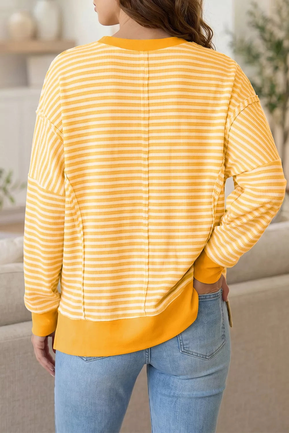 Yellow and white striped waffle-knit pullover with long sleeves and back seam