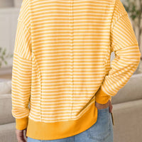 Yellow and white striped waffle-knit pullover with long sleeves and back seam
