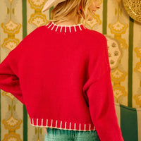 Red sweater back with white fringe-trim collar and cuff bands